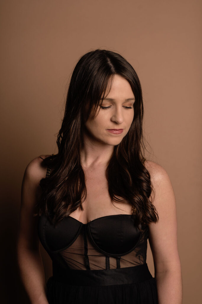 woman in black sheer dress looking down her shoulder