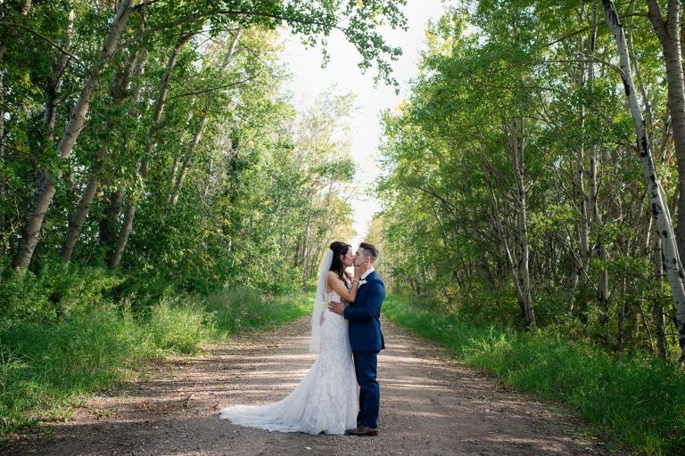 bride and groom kissing on a dirt road
