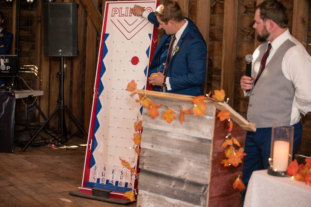 groomsmen playing plink in barn at wedding reception