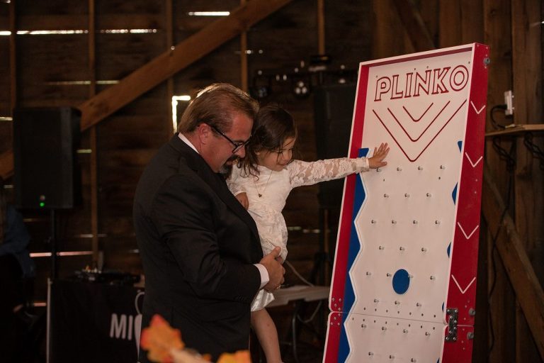 grandfather and granddaughter playing plinko at wedding reception